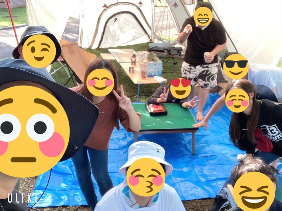 キャンプ場のテントの前でみんなで集まっている様子
