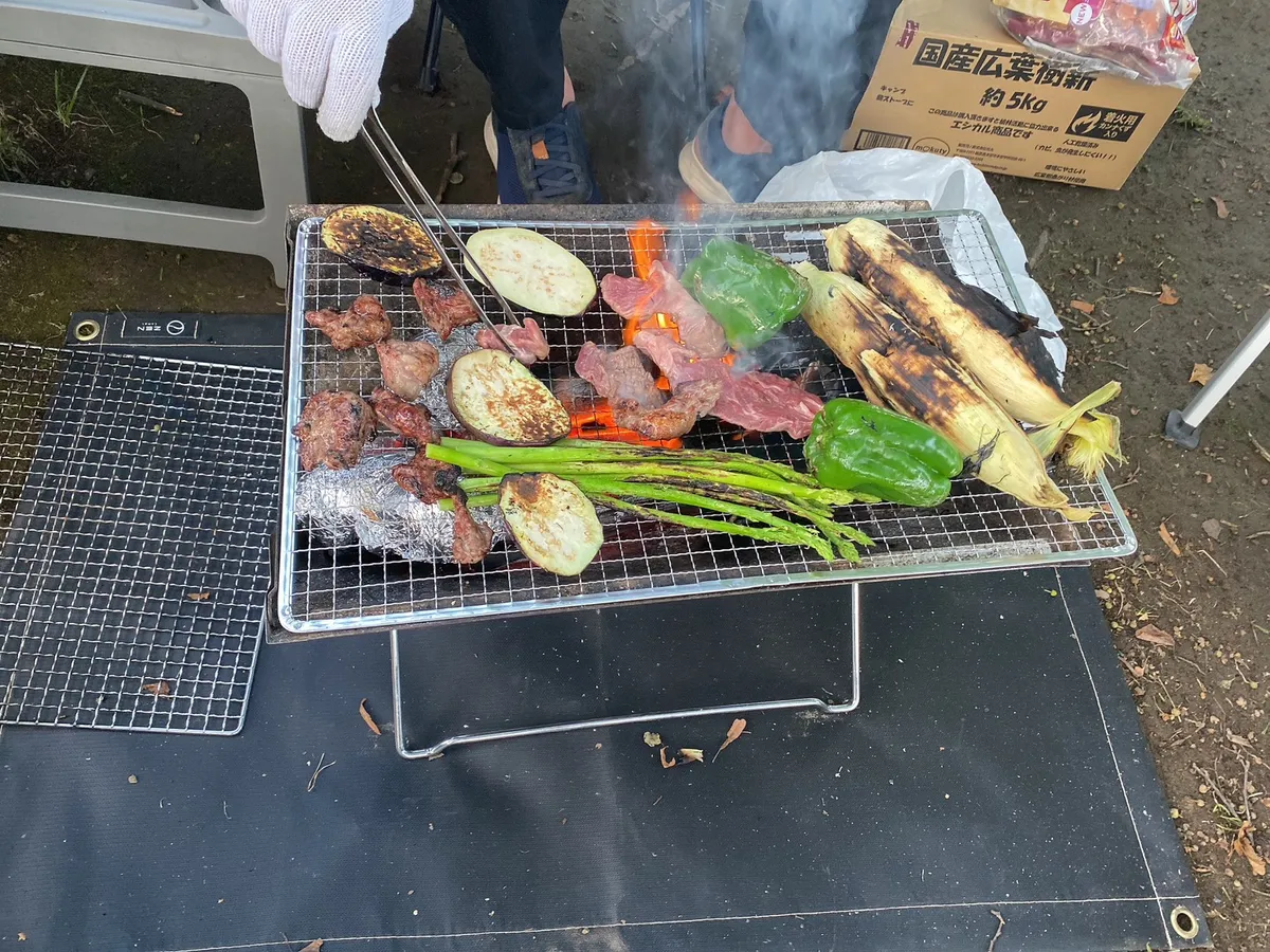 キャンプ場で野菜と肉を焼いている様子